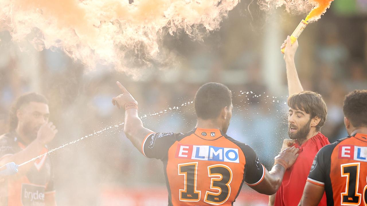 Joe Ofahengaue of the Tigers holds a pitch invader carrying a flare during the round five NRL match between the Cronulla Sharks and the Wests Tigers. Picture: Mark Kolbe/Getty Images