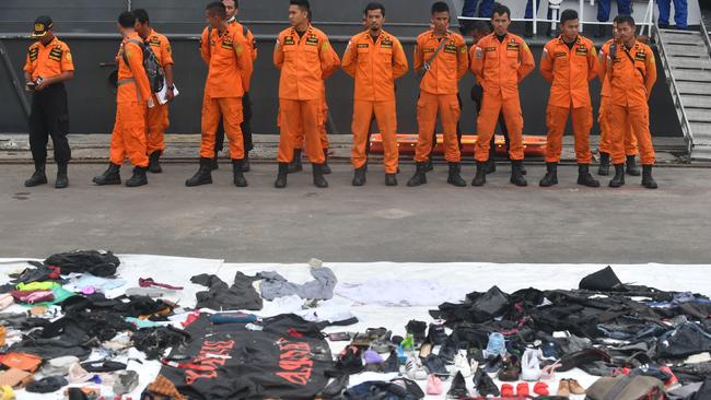 Recovered personal items of passengers on board the ill-fated Lion Air flight JT 610 are laid out as search and rescue personnel stand in formation.