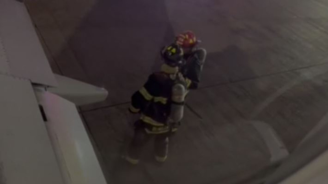 Fire crews seen inspecting the right engine after the emergency landingCredit: KABC
