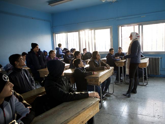 DAMASCUS, SYRIA - DECEMBER 15: A teacher addresses students in the classroom of the Muhammad bin Al-Qasim Al-Thaqafi school as it reopens on December 15, 2024 in the Al-Maliki area of Damascus, Syria. The school reopened after a weeklong closure, as rebel forces in Syria retook the capital from longtime ruler Bashar al-Assad, who fled the country for Moscow. The fall of the Assad regime marks a new chapter for Syria, which has been mired in a multi-party civil war since 2011, sparked by the Arab Spring uprisings. (Photo by Ali Haj Suleiman/Getty Images) *** BESTPIX ***