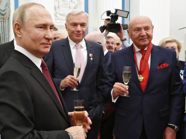 Russian President Vladimir Putin shares a drink with laureats after a state awards ceremony at the Kremlin in Moscow on December 20, 2022. (Photo by Valery SHARIFULIN / SPUTNIK / AFP)
