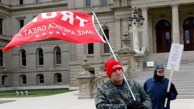 Supporters of President Donald Trump gather on the steps the Michigan state capital.