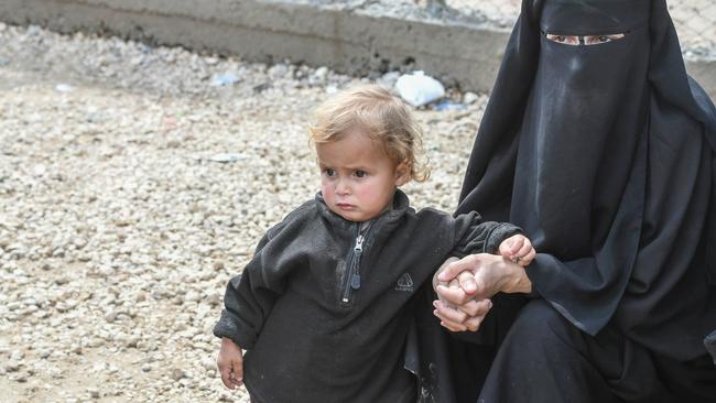 A foreign woman, living in Al-Hol camp which houses relatives of Islamic State group members, sits next to her child in the camp. Picture: AFP