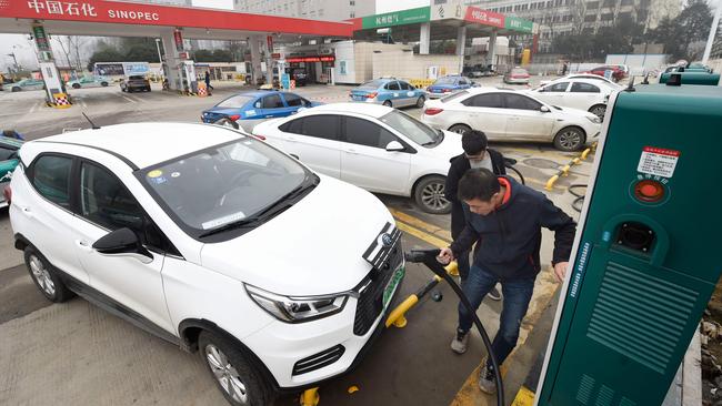 A man plugging in an electric vehicle at a Sinopec service station in Hangzhou, in China's eastern Zhejiang province. Picture: AFP