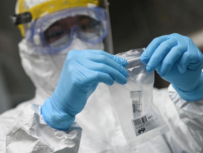 This photo taken on April 21, 2020 shows a medical staff member collecting a sample at a middle school as students receive nucleic acid testing for the COVID-19 coronavirus in Guangzhou in China's southern Guangdong province. - Companies, schools and individuals across China are lining up to be tested for the virus as the country rises back to normal life after largely taming the epidemic. (Photo by STR / AFP) / China OUT / TO GO WITH Health-virus-China-tests,FOCUS by Qian Ye