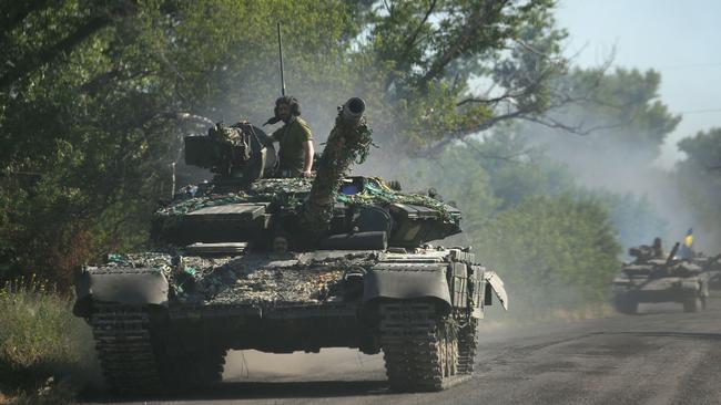 Ukrainian troops move by tanks on a road of the eastern Ukrainian region of Donbas. Picture: AFP