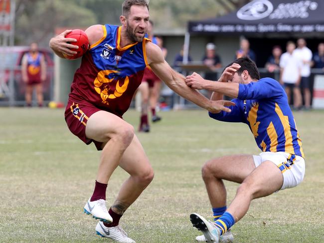 Travis Cloke of Tyabb brushes off an opponent and kicks for goal during the MPNFL Division 2 game between Tyabb and Somerville played at Bunguyan Reserve in Tyabb on Saturday 13th April, 2019.