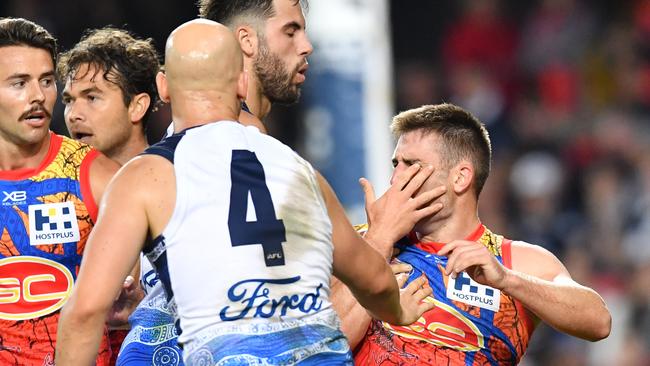 Anthony Miles clutches his face after a strike from Geelong star Gary Ablett. Picture: AAP Image/Darren England.