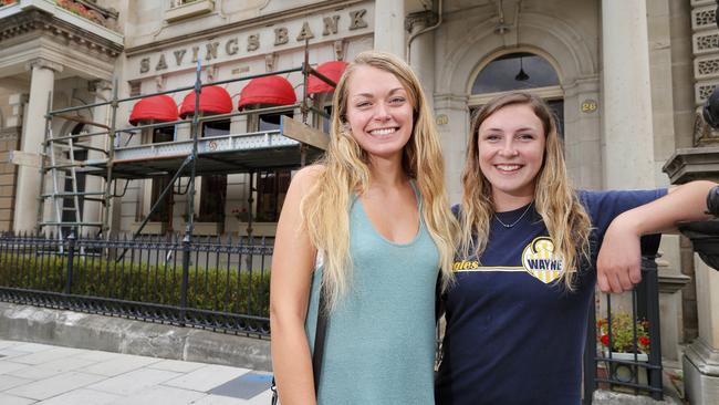 Tourists Kara Torrey, 19, from New England, left, and Cassidy Hadcock, 19, from New York, think the red awnings add character to the heritage building. Picture: RICHARD JUPE