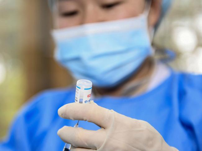 A medical worker prepares a dose of the Covid-19 coronavirus vaccine in Anlong, in China's southwestern Guizhou province on November 4, 2021, after the city began vaccinating children between the ages of 3 to 11. (Photo by AFP) / China OUT