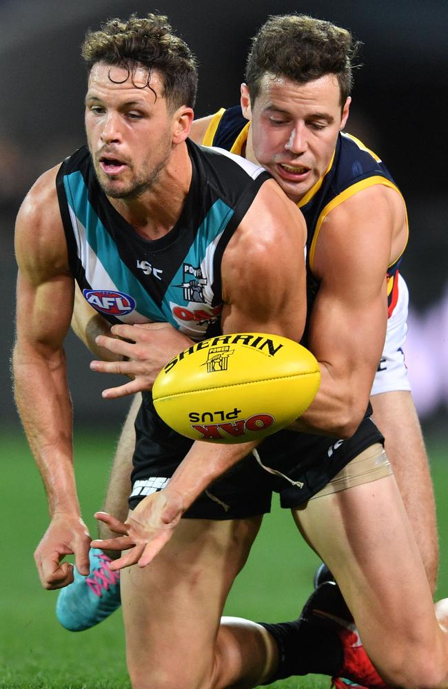 Travis Boak of the Power is tackled by Luke Brown of the Crows.