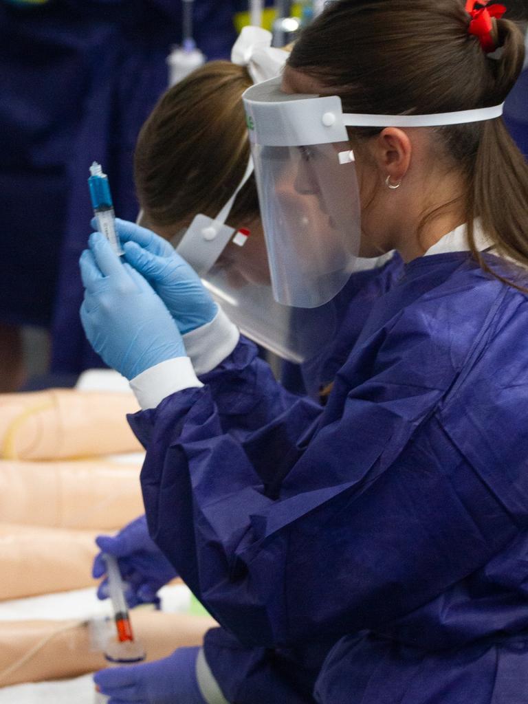 A future nursing student makes sure her measurement is correct.