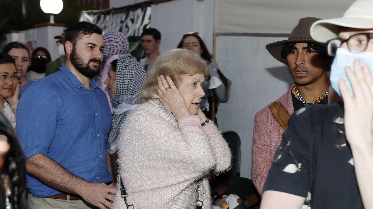 A woman covers her ears as she enters the Greek Club. Picture: Josh Woning