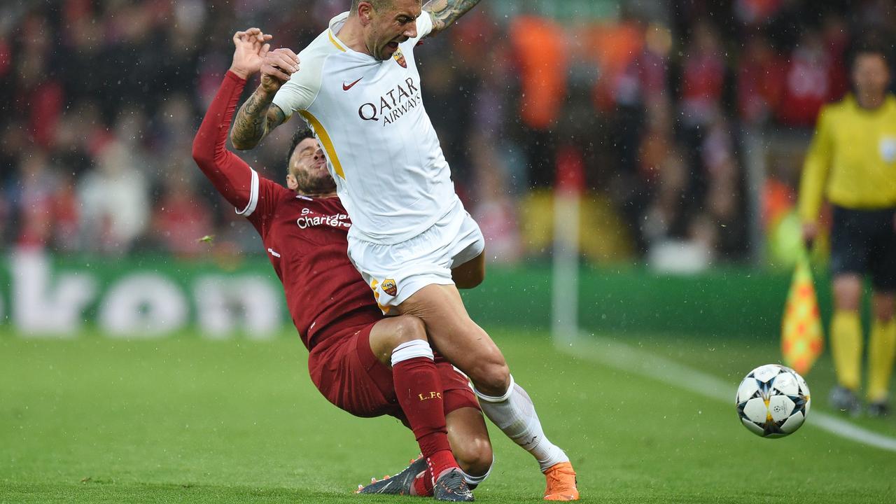 Alex Oxlade-Chamberlain (L) picks up the injury tackling Roma's Aleksandar Kolarov.