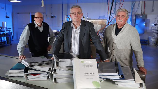 Ian Cook (centre), with retired Detective Sergeant Paul Brady (left) and retired Detective Inspector Rod Porter (right), with the mountain of evidence submitted to Victoria Police. Picture: Alex Coppel.