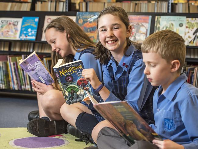 HILLS SHIRE TIMES/AAP. Dural Public School students (l-r) Jessica Turnbull, Yr 6, Alice Halbert, Yr 4, & Angus Tooke, Yr 2, read books in their school library at Dural on Monday, August 26. Dural Public School is participating in this year's Premiers Reading Challenge. (AAP IMAGE / Troy Snook)