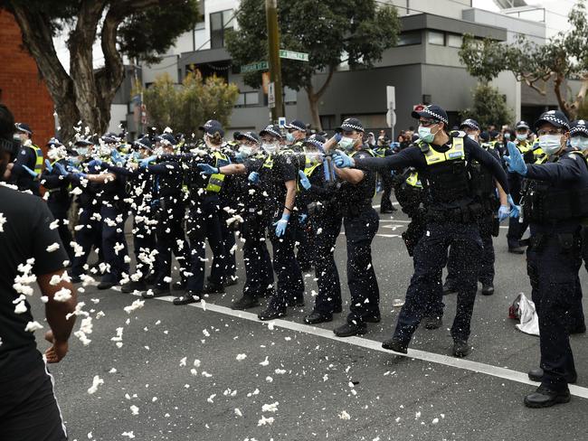 MELBOURNE, AUSTRALIA - SEPTEMBER 18: Police deploy capsicum spray onto protestors on Burnley Street Richmond on September 18, 2021 in Melbourne, Australia. Anti-lockdown protesters gathered despite current COVID-19 restrictions prohibiting large outdoor gatherings. Metropolitan Melbourne is currently subject to lockdown restrictions as health authorities work to contain the spread of the highly contagious Delta COVID-19 variant, with people only permitted to leave their homes for essential reasons. Victorian COVID-19 restrictions have been eased from today in Metropolitan Melbourne to allow outdoor picnics and small exercise groups, while the permitted travel distance from home has extended to 10km.  (Photo by Darrian Traynor/Getty Images)