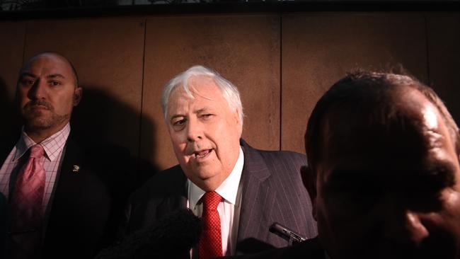Clive Palmer, flanked by four security guards, leaves the Federal Court in Brisbane today.