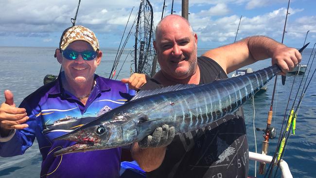 <s1>Steve Castle, left, with an extremely-rare NT wahoo is helped by Darwin Bluewater Charters crew member Gary Lee.</s1>