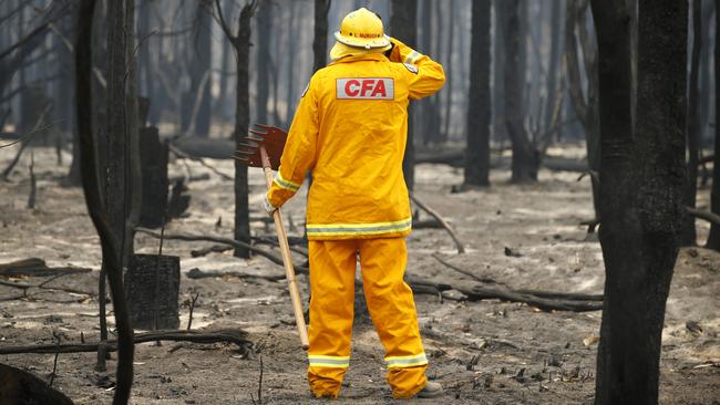 CFA firefighter Lindsay McHugh from South Morang checks smoldering trees in East Gippsland. Picture: David Caird