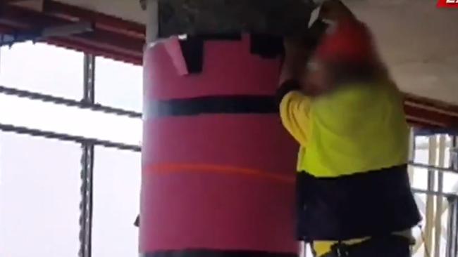 A support pillar is taped up by a construction worker.