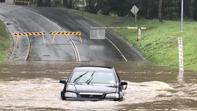 A Holden Commodore in floodwaters on Hardys Road at Mudgeeraba. Picture: Glenn Hampson