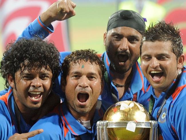 (FILES) In this photograph taken on April 2, 2011, Indian cricketer Sachin Tendulkar (2nd L) celebrates with teammates as he holds the trophy after beating Sri Lanka in the ICC Cricket World Cup 2011 final match at The Wankhede Stadium in Mumbai. Indian batting legend Sachin Tendulkar on December 23, 2012 announced his retirement from one-day cricket after scoring a record-breaking 49 centuries in the 50-over format.  AFP PHOTO/MANAN VATSYAYANA/FILES