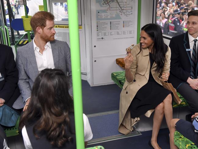 Prince Harry and Meghan ride on a Melbourne tram. Picture Pool/William West