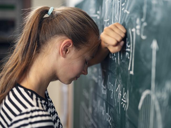 Teenage girl in math class overwhelmed by the difficult math formula. Shot with Nikon D850