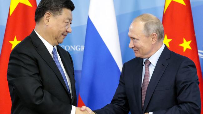 Russian President Vladimir Putin shakes hands with his Chinese counterpart Xi Jinping during an earlier meeting.