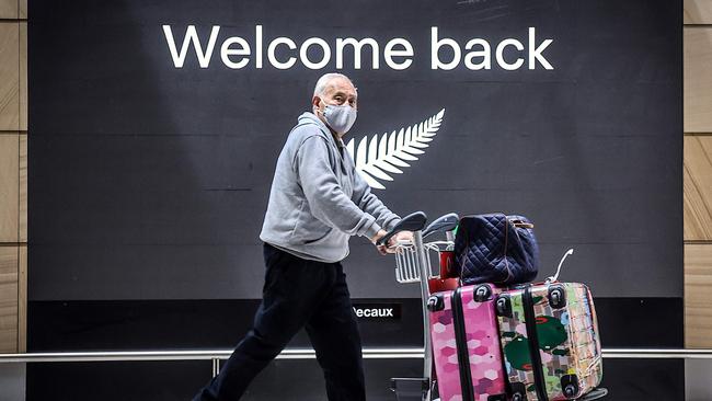 A passenger wearing a face mask arrives from New Zealand at Sydney International Airport.