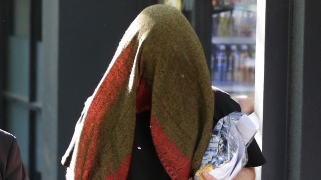 Thomas Elliott covers his face after being released on Wednesday on strict conditional bail. Picture: Christian Gilles