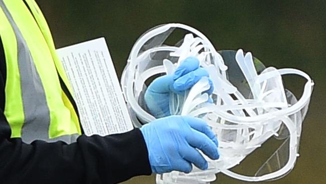 A member of staff carries safety eye glasses at a drive-in facility to test NHS workers for the novel coronavirus COVID-19 at the Chessington World of Adventures Resort in Greater London.