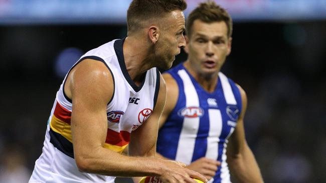 Crows star Brodie Smith under pressure from North Melbourne’s Shaun Higgins at Marvel Stadium on Saturday night. Picture: AAP Image/Hamish Blair