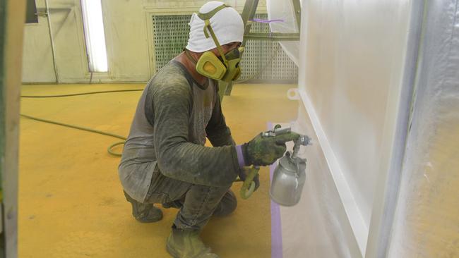 Migrant worker Raphael Gumabon spray painting at Ingham-based Carta &amp; Co, the largest manufacturer of cane transporters in Australia. Picture: Cameron Bates