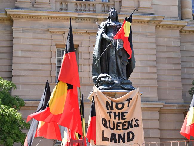 BRISBANE, AUSTRALIA - NewsWire Photos - JANUARY 26, 2021. The Aboriginal flag is placed on a statue of Queen Victoria as protesters gather for an Invasion Day rally in Queen's Gardens in central Brisbane. As the nation marks this day as Australia Day, indigenous groups and their supporters refer to it as Invasion Day or Survival Day. Picture: NCA NewsWire / Dan Peled