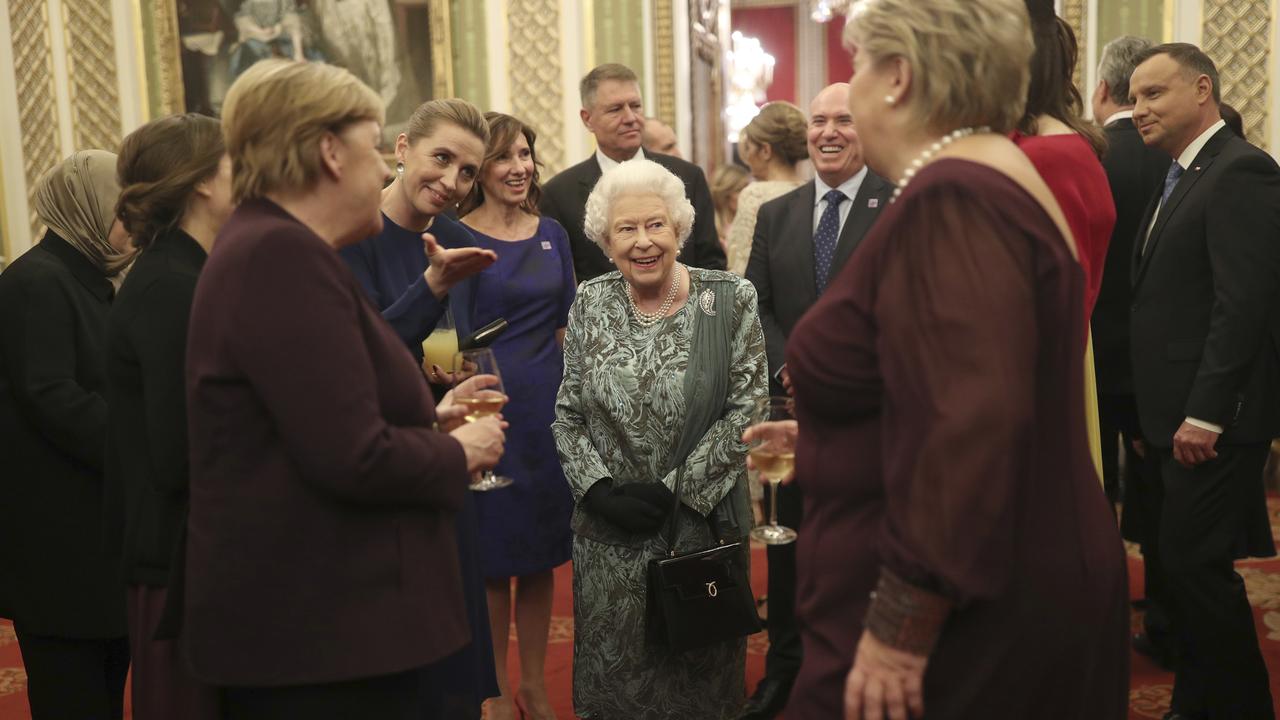 The Queen looks happy as she chats with guests at Buckingham Palace including Germany's Chancellor Angela Merkel and Norway's Prime Minister Erna Solberg. Picture: Yui Mok/AP