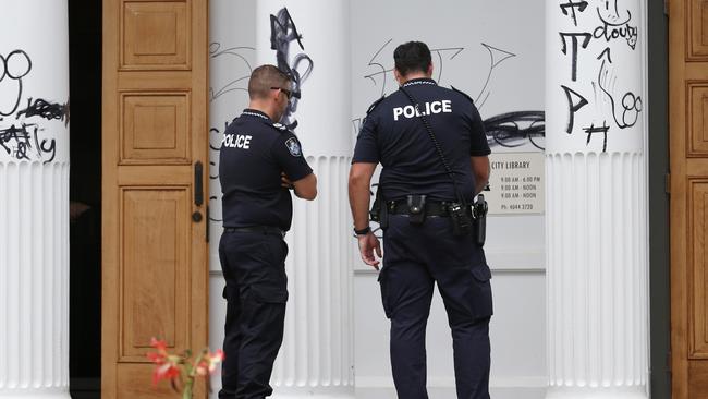 The Cairns Library on Abbott Street in the CBD has been graffitied with numerous tags, crude comments and genital drawings in what appears to be a targeted and prolonged attack. Police officers investigate the crime scene. Picture: Brendan Radke