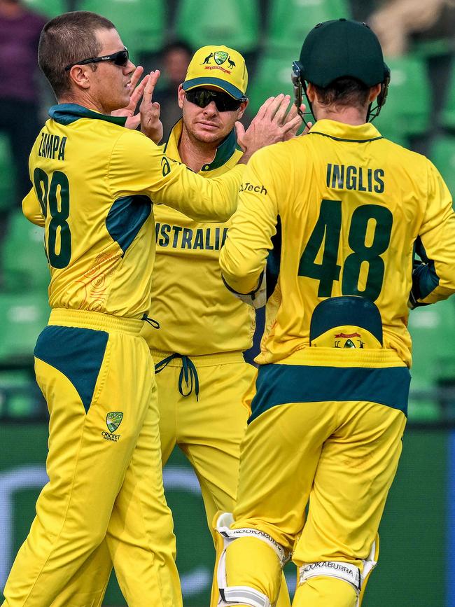 Adam Zampa celebrates with Steve Smith after taking the wicket against Afghanistan last week. Photo: AFP