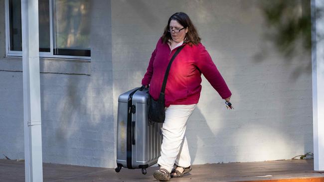 Erin Patterson seems to be allergic to having her photo taken as she scurries from her front door to her MG SUV. Picture: Jason Edwards