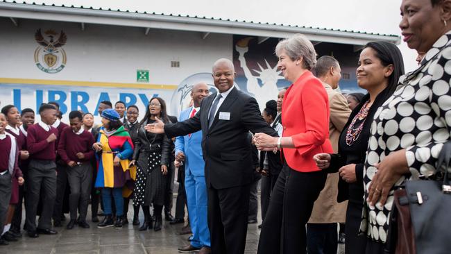 Theresa May (C-r) joins schoolchildren in dancing a visit to the ID Mkhize Secondary School in Gugulethu, about 15km from the centre of Cape Town. Picture: Rodger Bosch/AFP