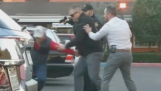 Officers take a man identified as Zhao Chunli into custody following multiple shootings in Half Moon Bay that left at least seven people dead. Picture: ABC affiliate KGO