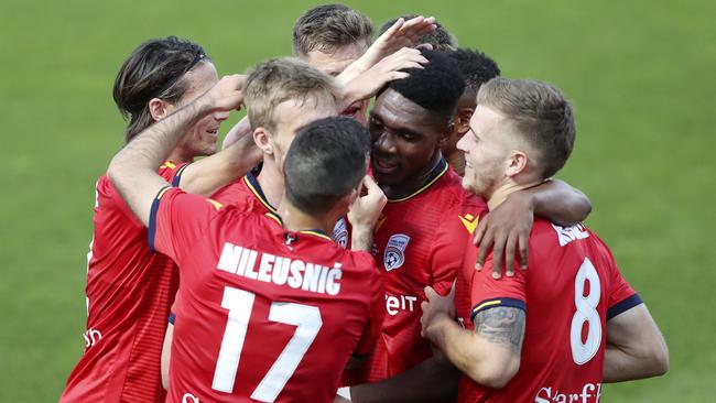 Adelaide United striker Al Hassan Toure is mobbed by teammates, following his FFA Cup final goal. Picture: Sarah Reed