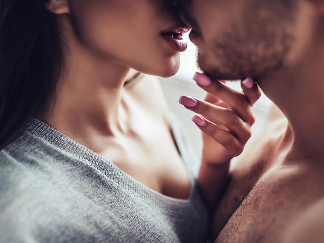 Close-up of young romantic couple is kissing and enjoying the company of each other at home.