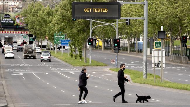 A couple walks their dog on Punt Rd on Sunday morning during stage four restrictions in Melbourne. Picture: NCA NewsWire/David Geraghty