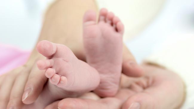 Generic photo illustrating IVF. Mother's hands holding Baby's tiny feet. Picture: iStock