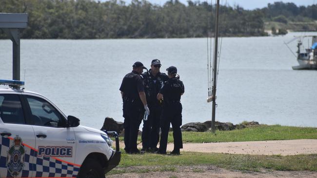 Police investigate the scene on the banks of the Burnett River and interview boaties following a serious boat crash.