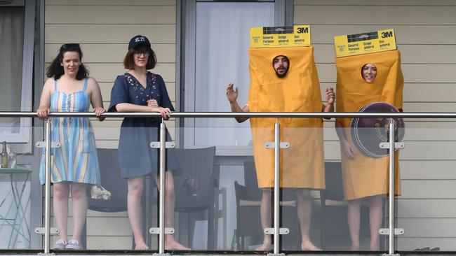 Two fans, watching in an adjacent building, dressed up as giant sheets of sandpaper. Picture: AFP