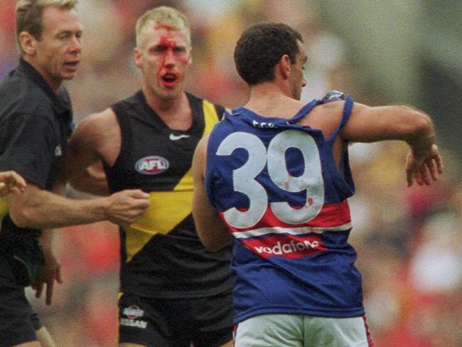 A bloodied Matthew Knights battled Tony Liberatore on the MCG in 2001.