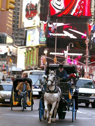 A horse-drawn carriage makes its way down Broadway in New York's Times Square.